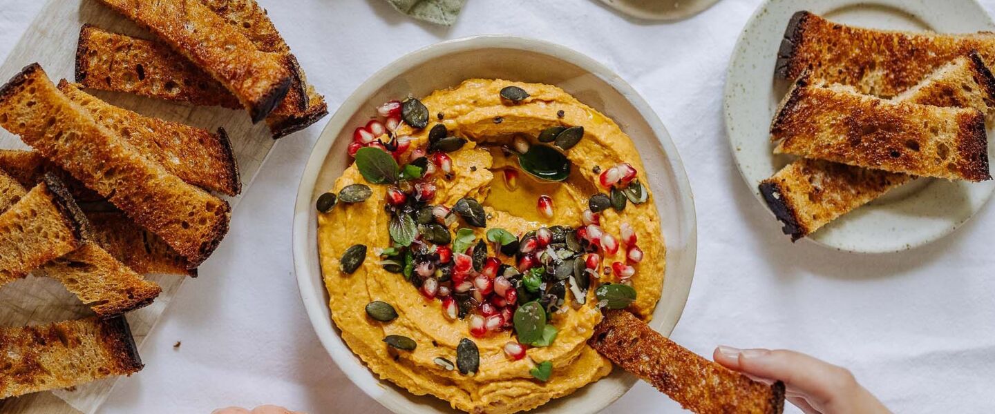 Ölz Landbrot Dinkel Brotchips mit Süßkartoffelhummus, gerösteten Kürbiskernen und Granatapfel